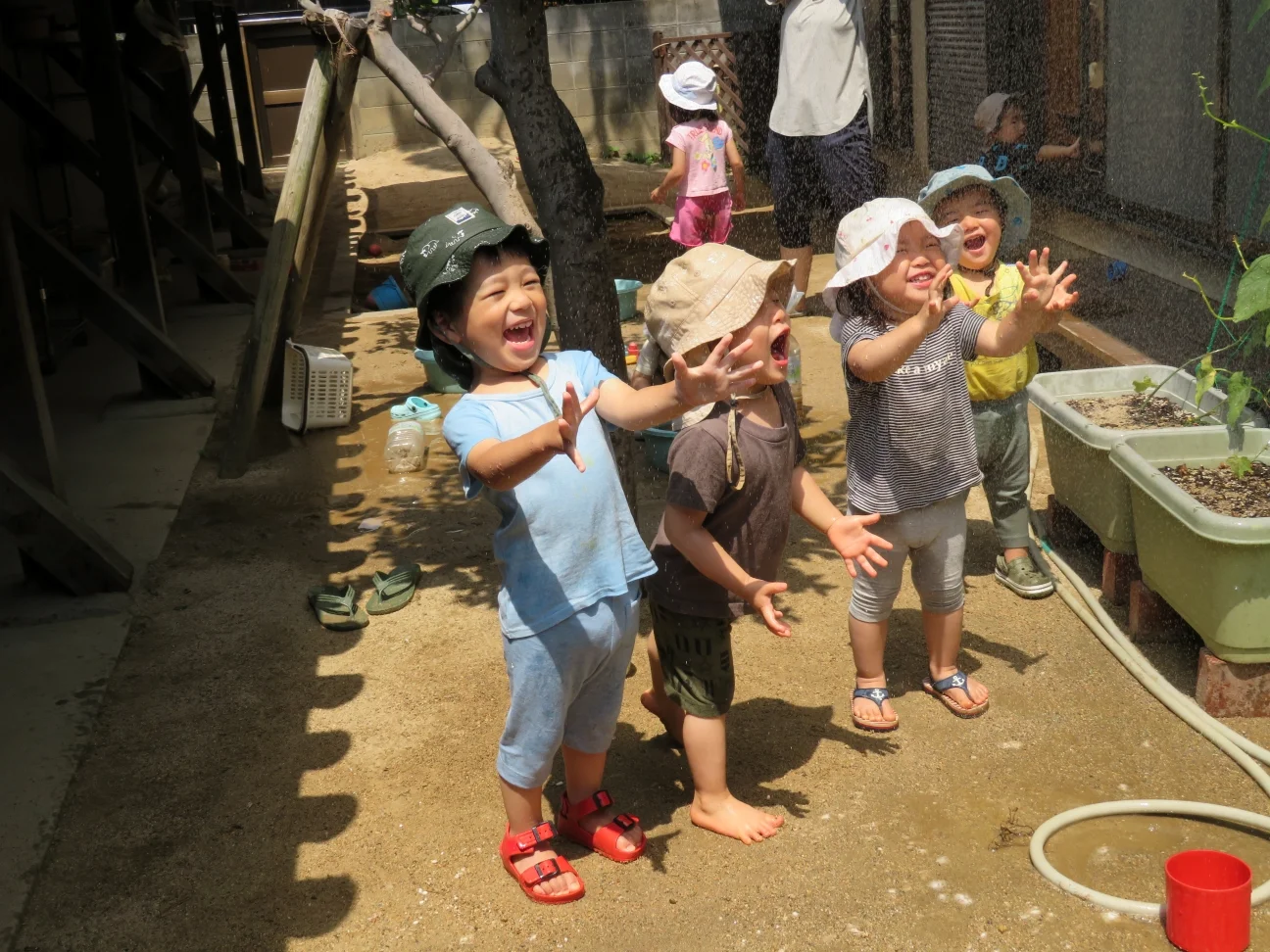 水遊びで手を伸ばす園児